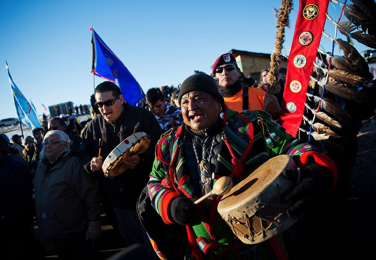 Dan Nanamkin, of the Colville Nez Perce Native American tribe in Nespelem, Wash., right, drums with a procession through the Oceti Sakowin camp in Cannon Ball, N.D., Dec. 4, 2016.