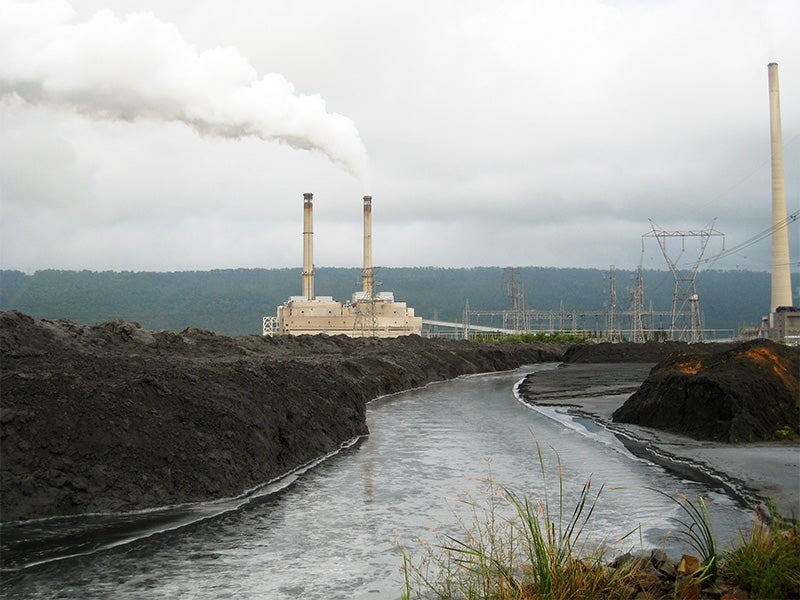 A power plant located next to a waterway.