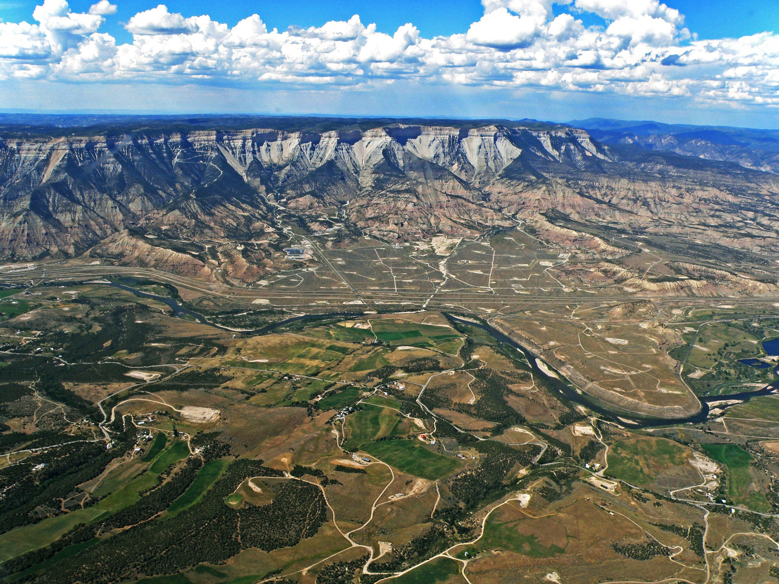 The valley below the Roan Plateau is dotted by oil and gas development.