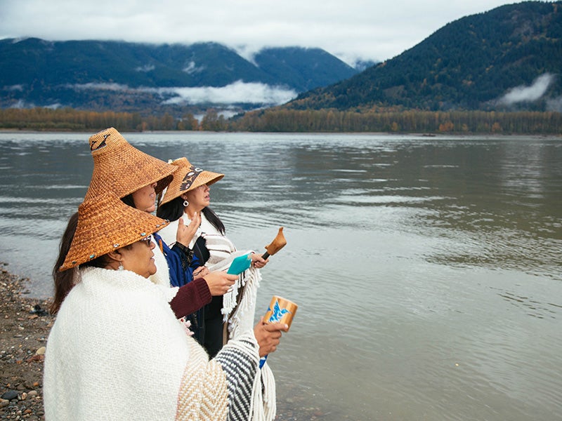 Members of the Tulalip Tribe sing along the banks of the Fraser River in Chilliwack, British Columbia, as part of a ceremony to honor the waters and marine life so integral to the Coast Salish way of life.