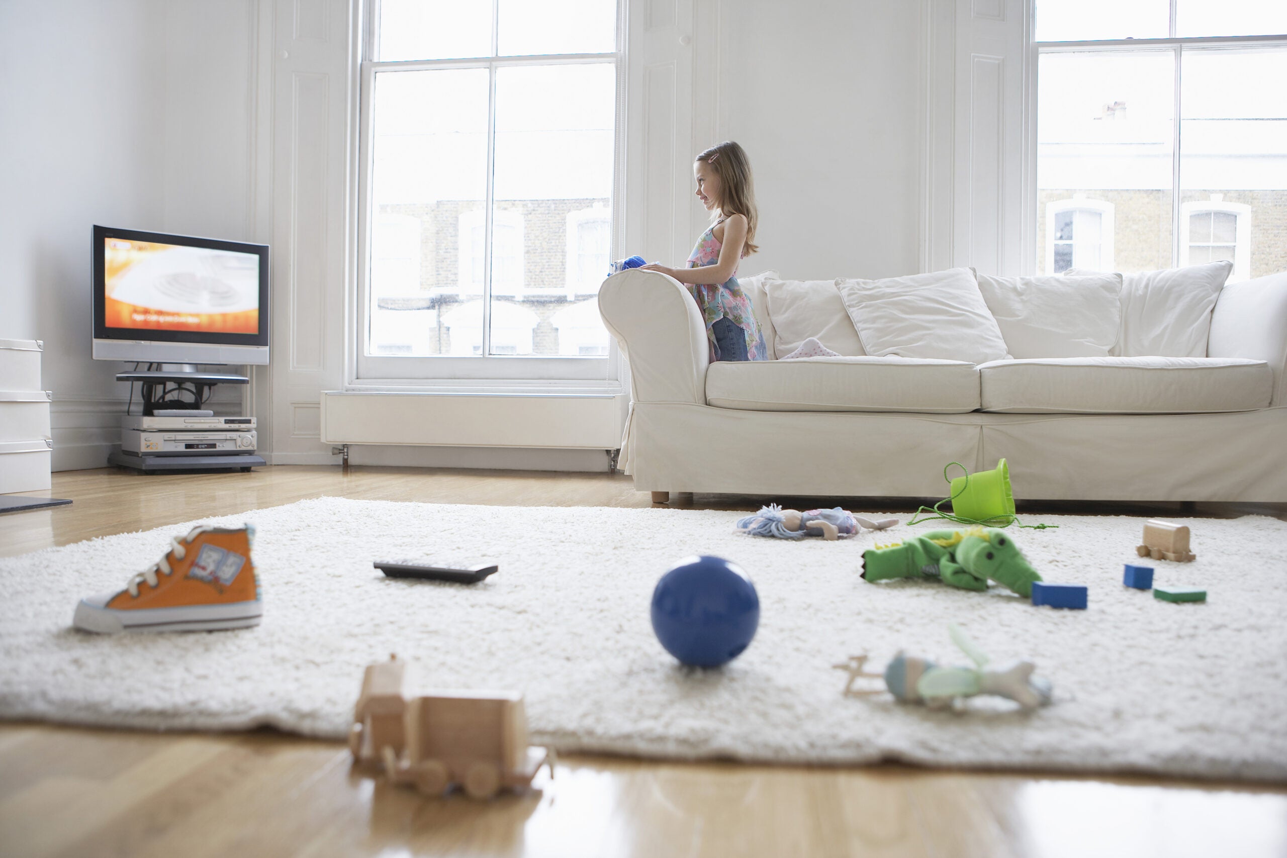 girl on couch with toys on floor