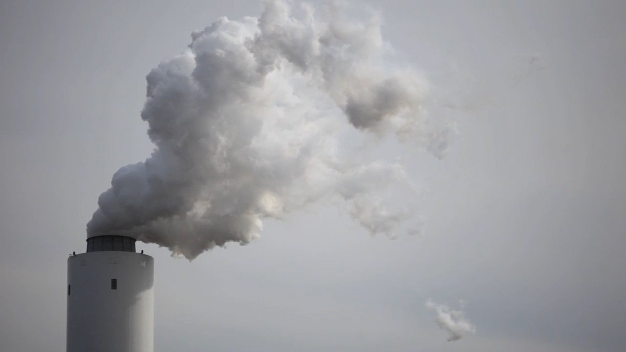 Air pollution billows out from a coal-fired power plant&#039;s smokestacks.