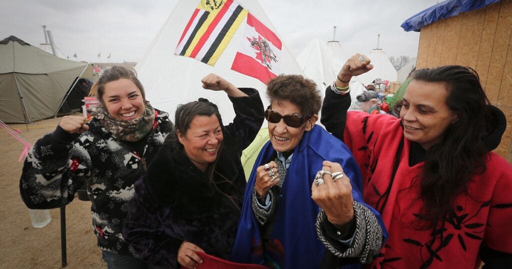 At the Oceti Sakowin Camp in 2016, Taylor Peterson, Katherine Morrisseau, Nancy Scanie, and Fawn Youngbear-Tibbetts (left to right). Clan Grandmother Nancy Scanie from Cold Lake Dene First Nation in Alberta Canada represented the Athabasca Keepers of the Water.
(Joey Podlubny / CC BY-NC 2.0)