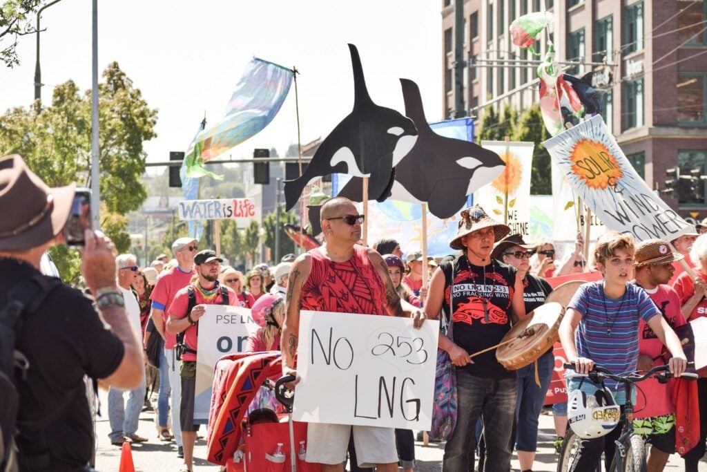 A coalition of groups concerned about the proposed fracked-gas storage facility rallied in August 2019 before a Puget Sound Clean Air Agency hearing. Signs oppose LNG in Tacoma, where the area code is 253.
(Rachel Lee for Washington Environmental Council)