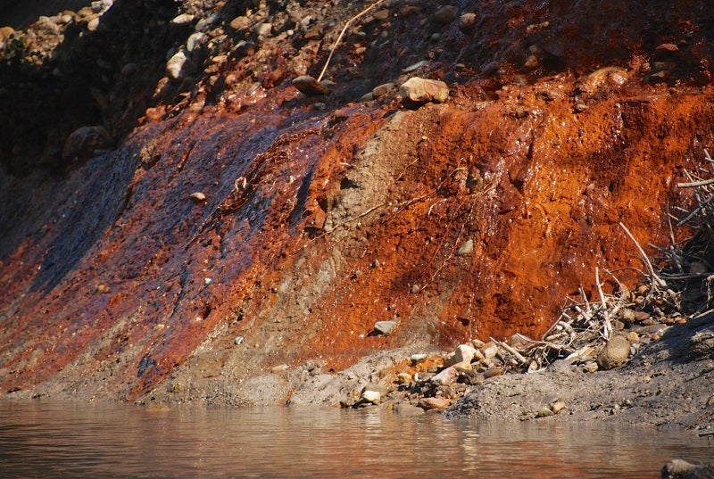 Toxic coal ash waste, the red material in the river bank, from Dynegy’s Vermilion Power Plant in Oakwood, Illinois, can be seen leaking into the Middle Fork of the Vermilion River.
(Courtesy of The Prairie Rivers Network)