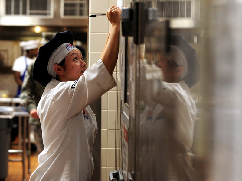 A food service specialist with the 55th Force Support Squadron marks down the exact temperature of one of three walk-in freezers at a dining facility.
(Josh Plueger / U.S. Air Force)