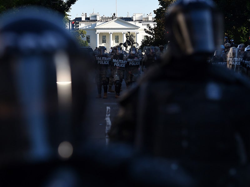 La policía militar acordona un perímetro aledaño a la Casa Blanca mientras un grupo de manifestantes se congrega en Washington, D.C. el 1 de junio de 2020, para protestar contra el asesinato de George Floyd.